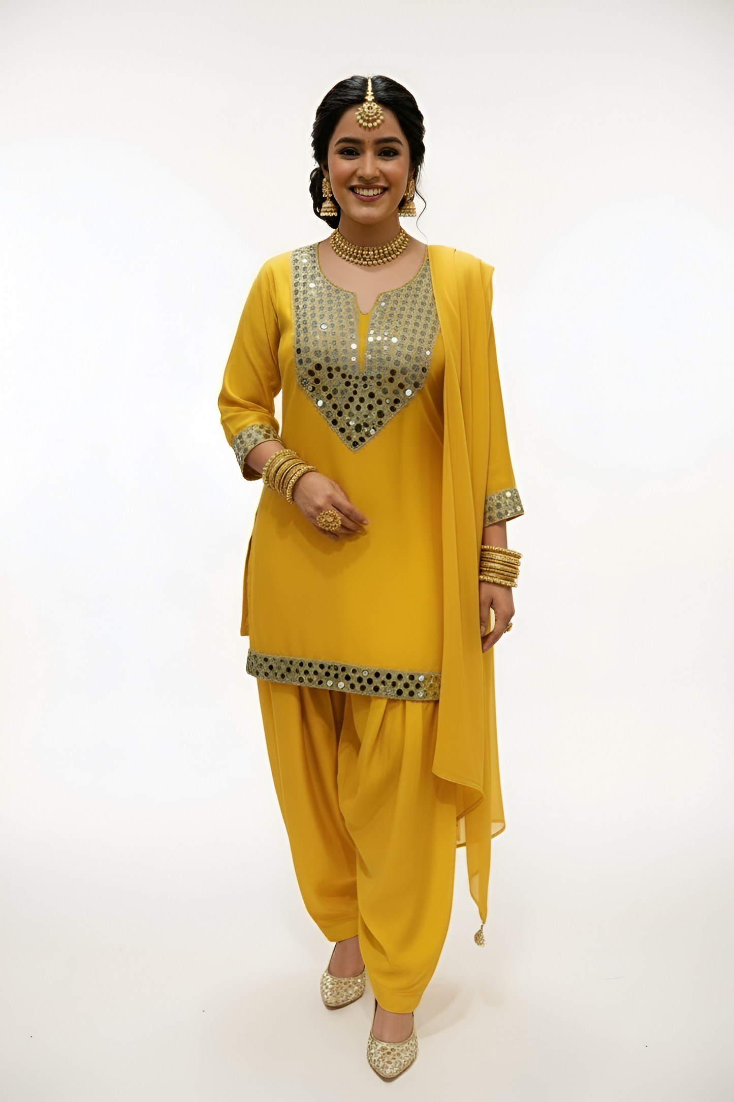 This Mirror Work Patiala Suit in Mustard Glow is crafted from luxurious dola silk, offering both comfort and elegance.